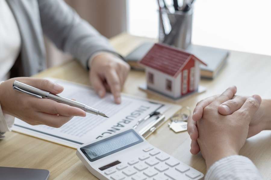 Une personne pointe un document de contrat avec un stylo lors d'un rendez-vous sur la gestion locative.